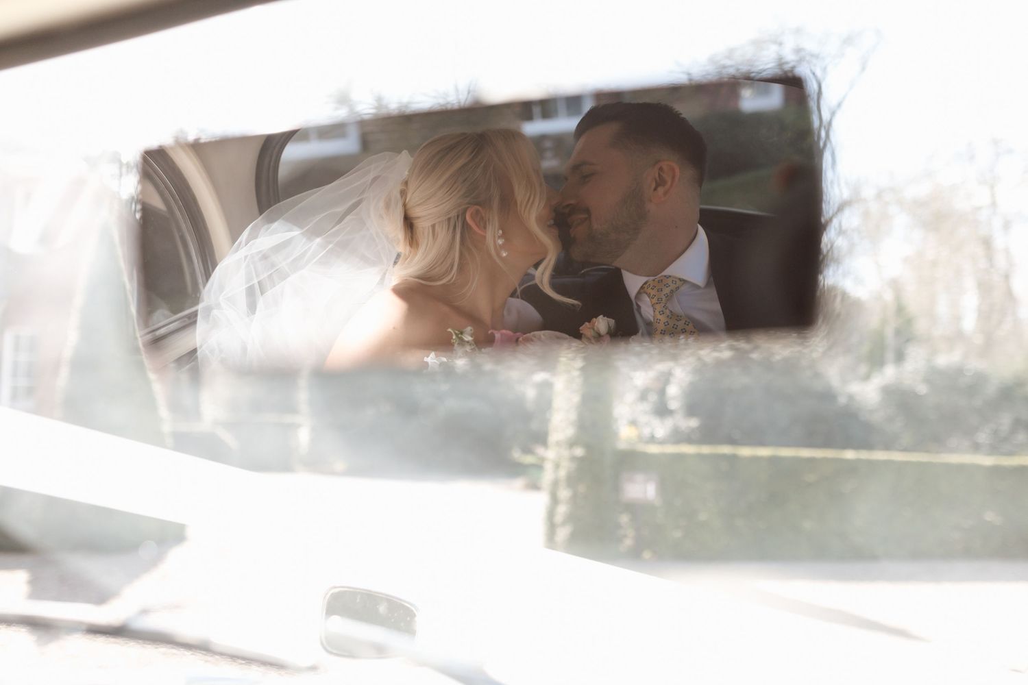 A soft-focus romantic moment captured through a car window with a dreamy, ethereal quality.