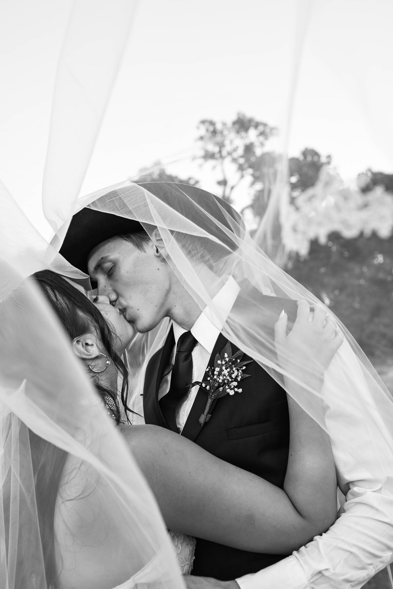 Bride and groom kissing under the veil at The Barn at Broken Horn Ranch in Luther, Oklahoma.