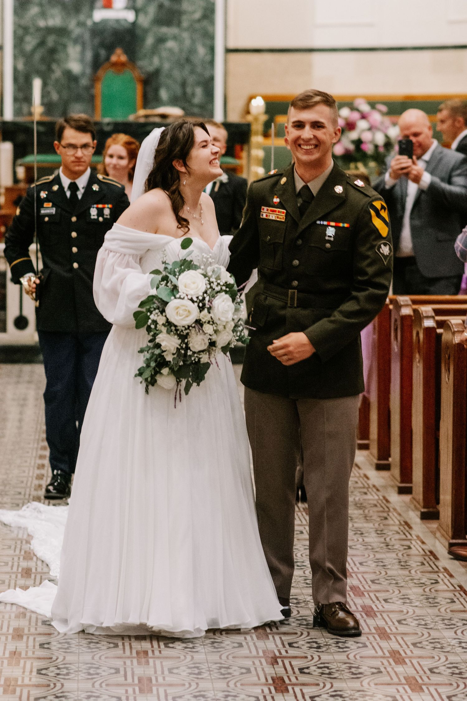 Bride and groom laughing as they walk down the aisle, post vows at Coprus Christi Cathedral in Corpus Christi, Texas
