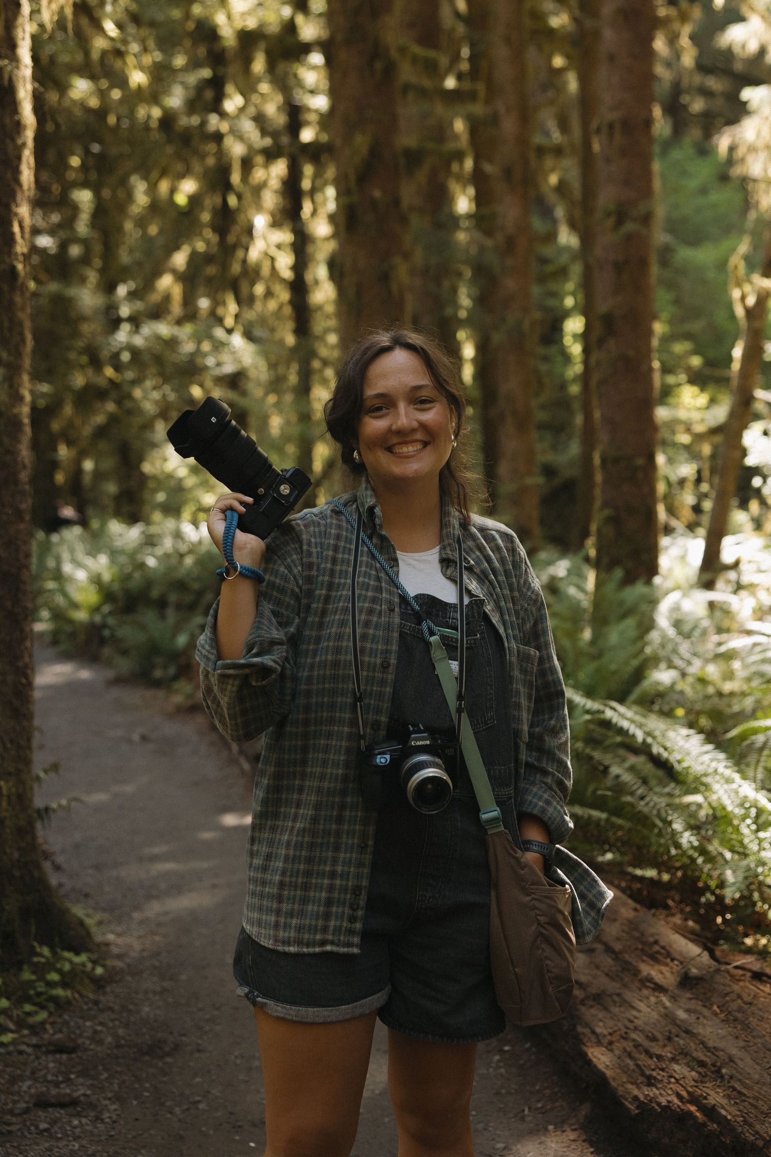photographer with nikon camera smiling in Hoh Rainforest in Olympic National Park, Washington
