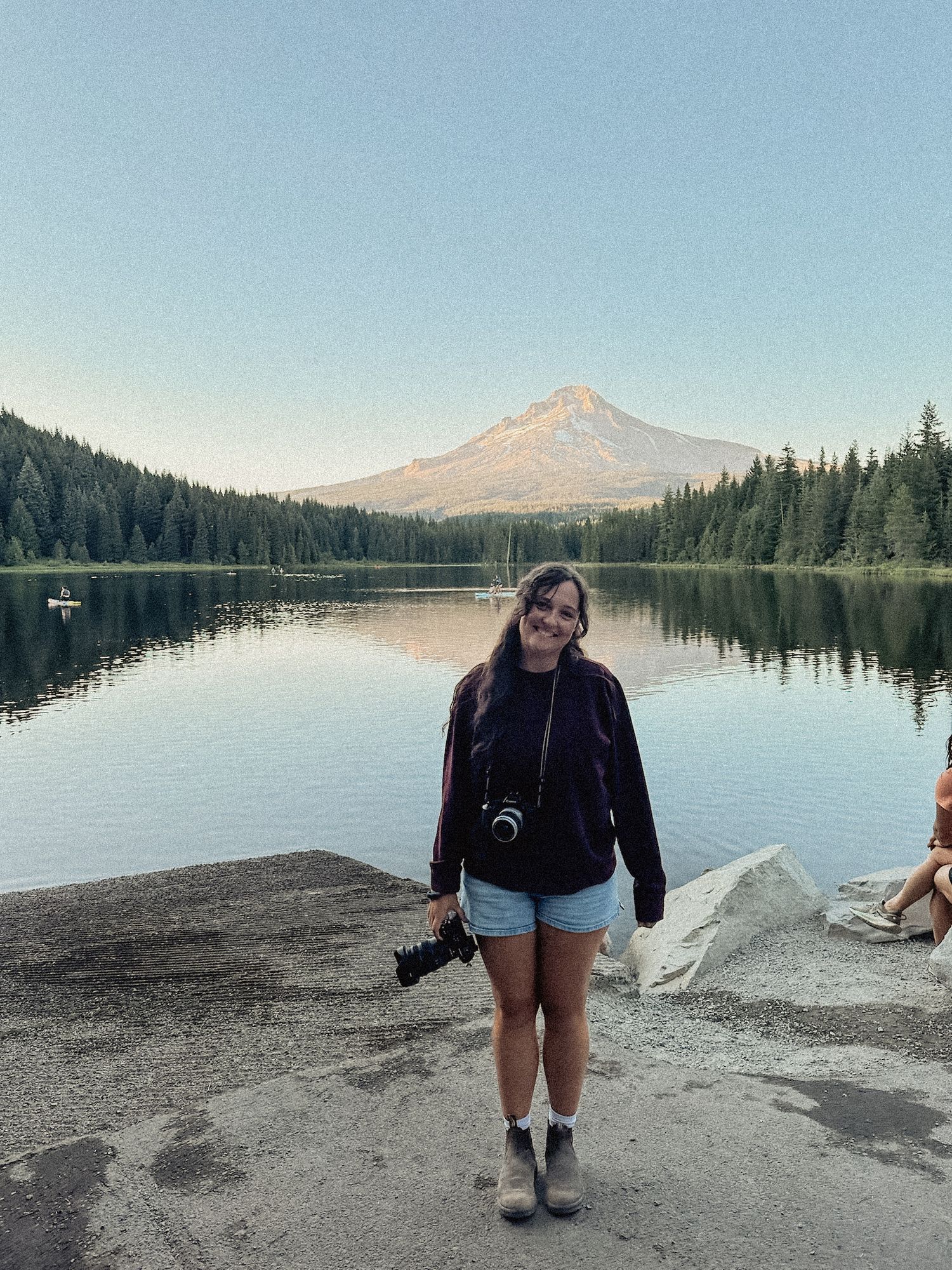 Photographer with camera standing in front of aMount Hood at Trillium lake in Oregon.