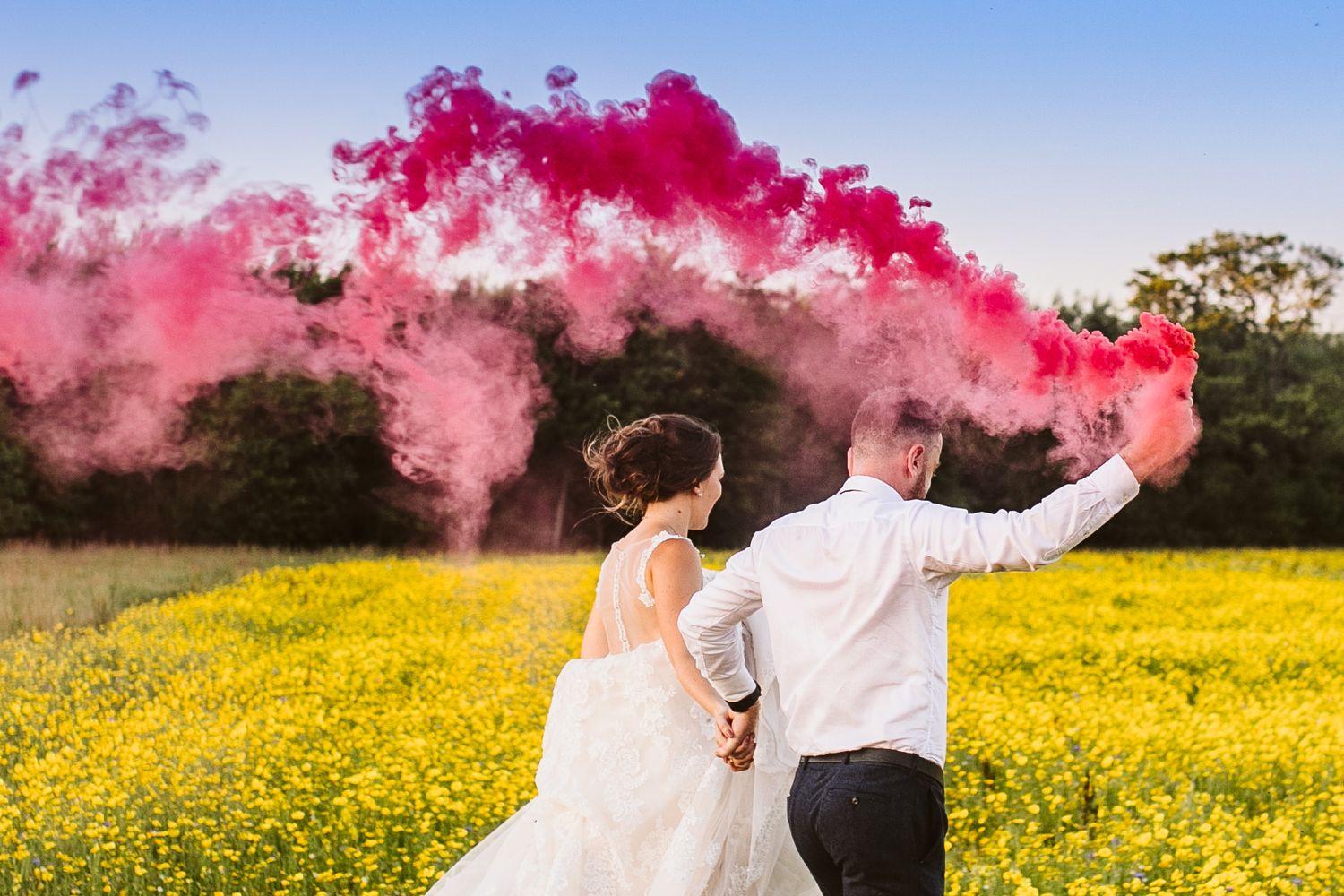 red smoke bomb is carried by bride and groom