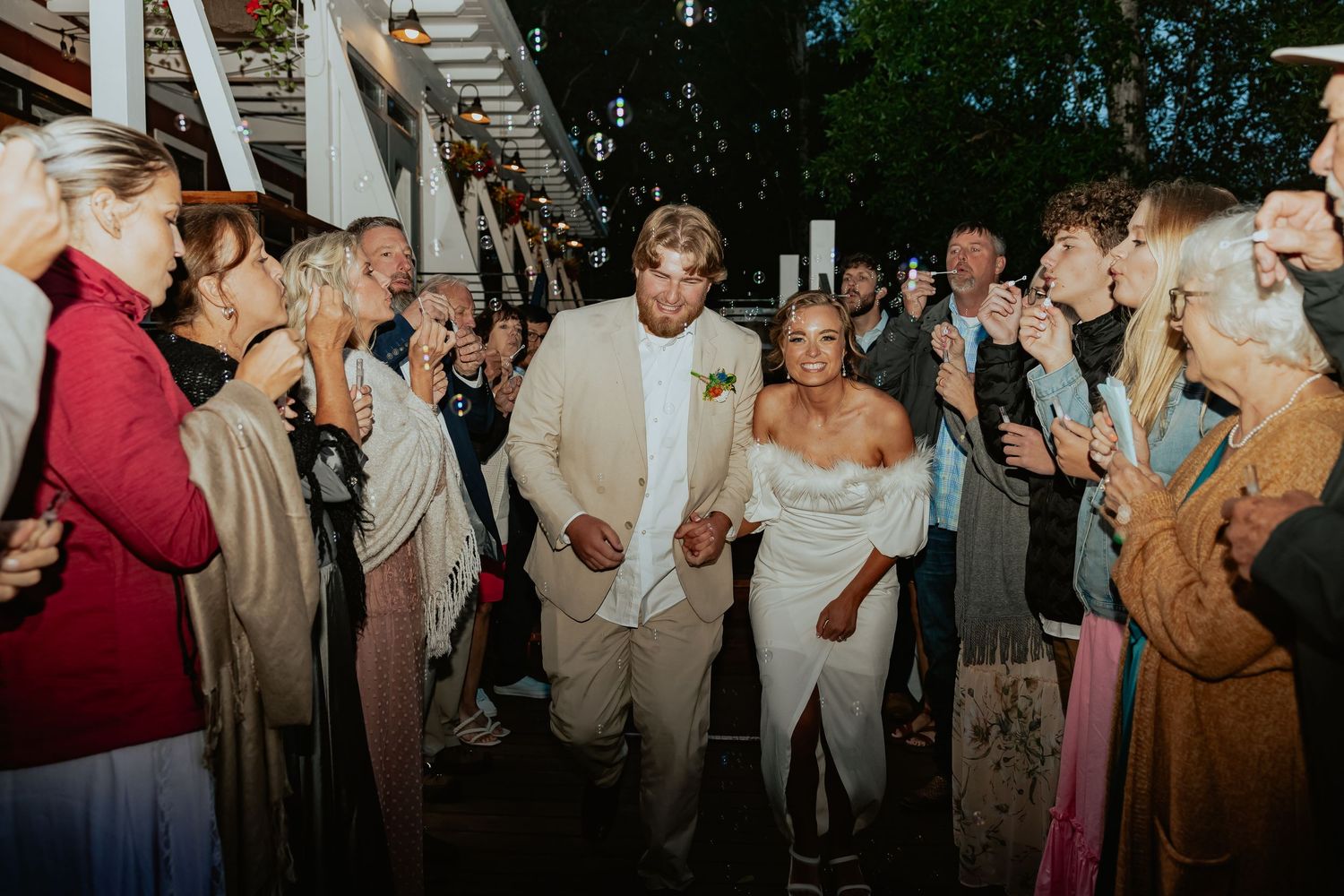 Wedding guests dancing and celebrating at an evening outdoor reception.