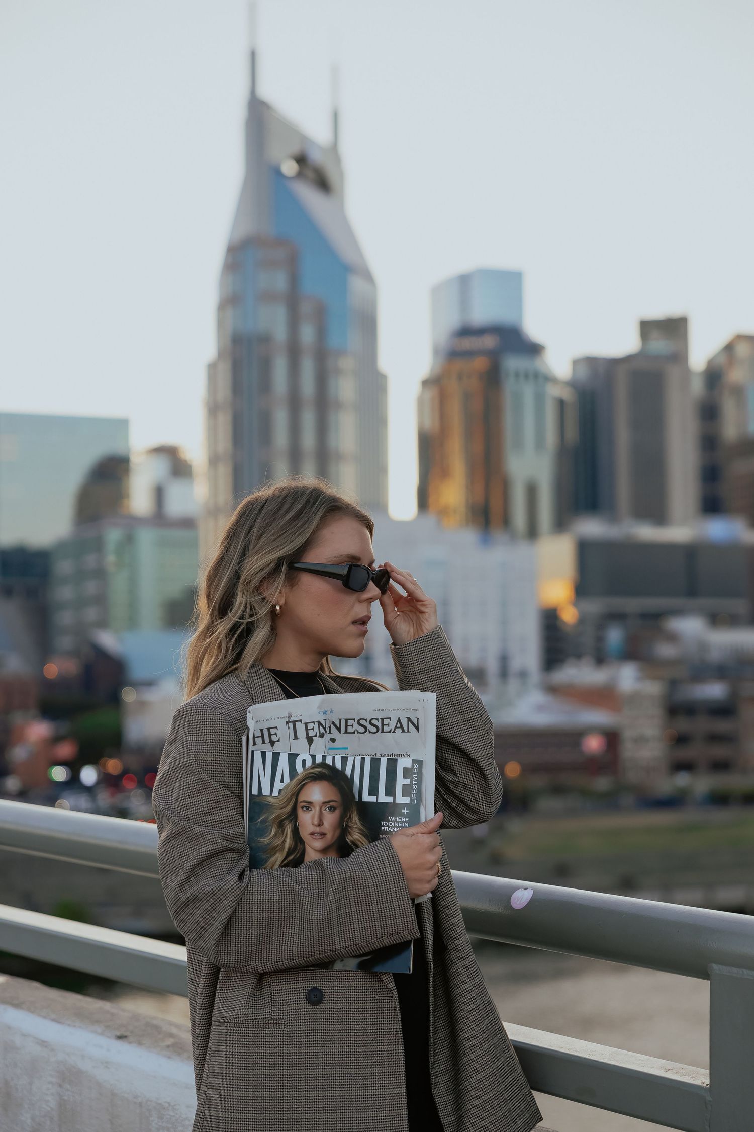 A person in a plaid blazer poses against the Nashville skyline at different angles during golden hour.