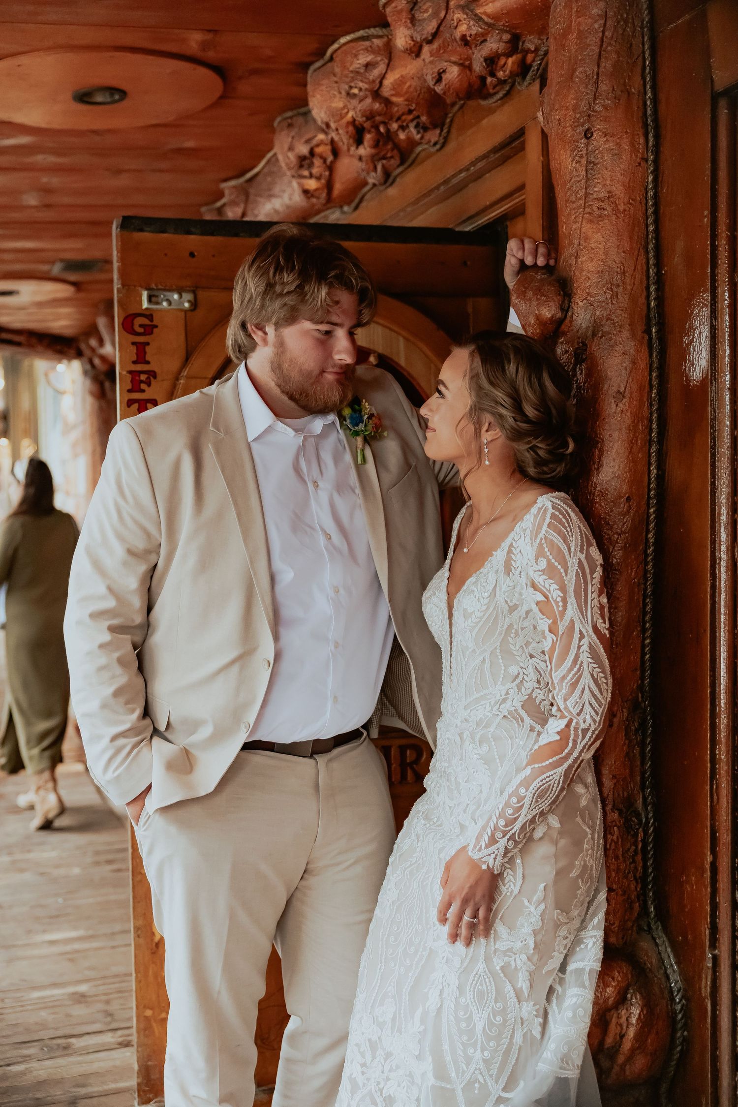 Wedding couple sharing an intimate moment against rustic wooden walls.