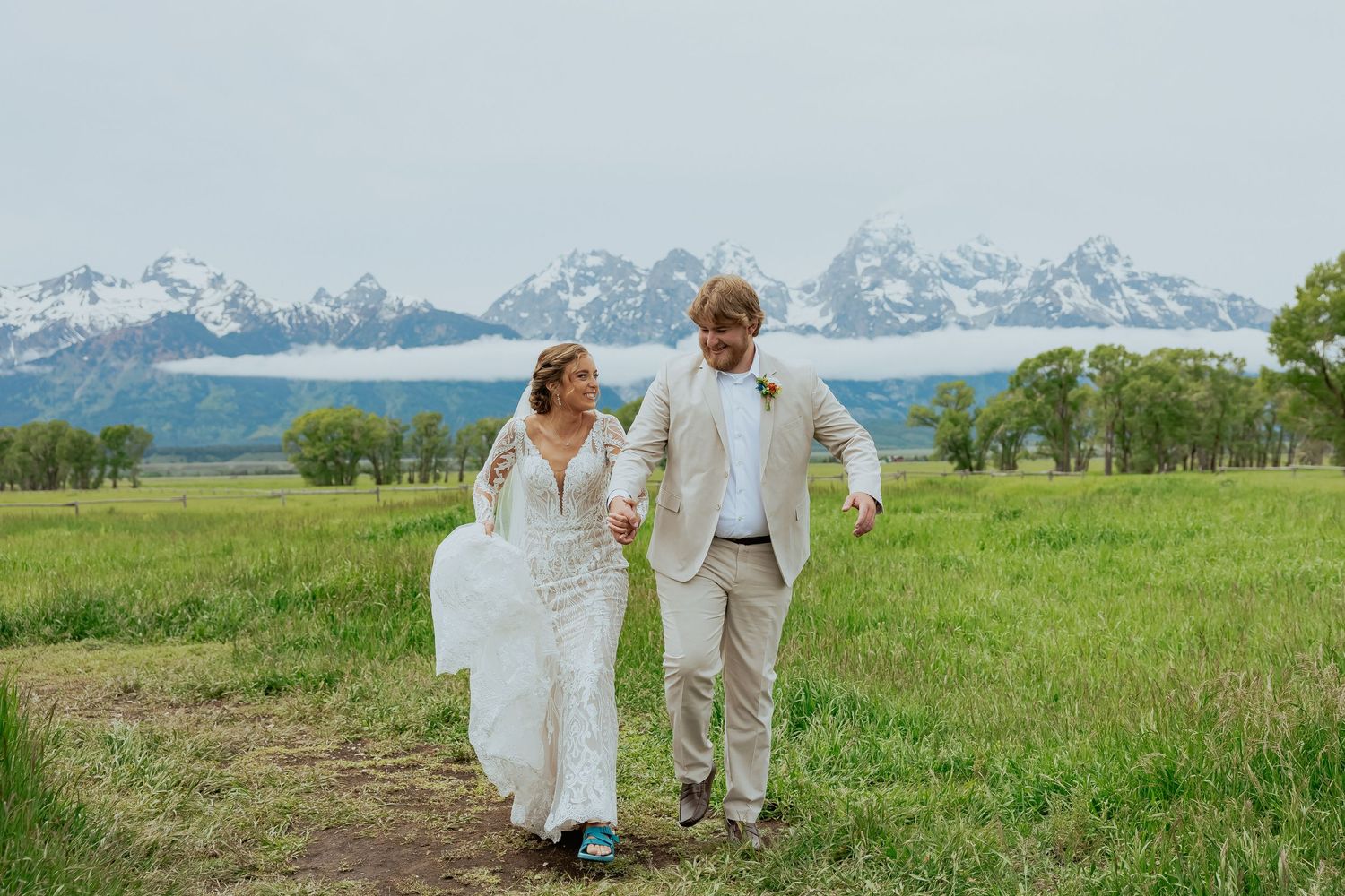 A romantic wedding photoshoot in a meadow with majestic mountain peaks as the backdrop.