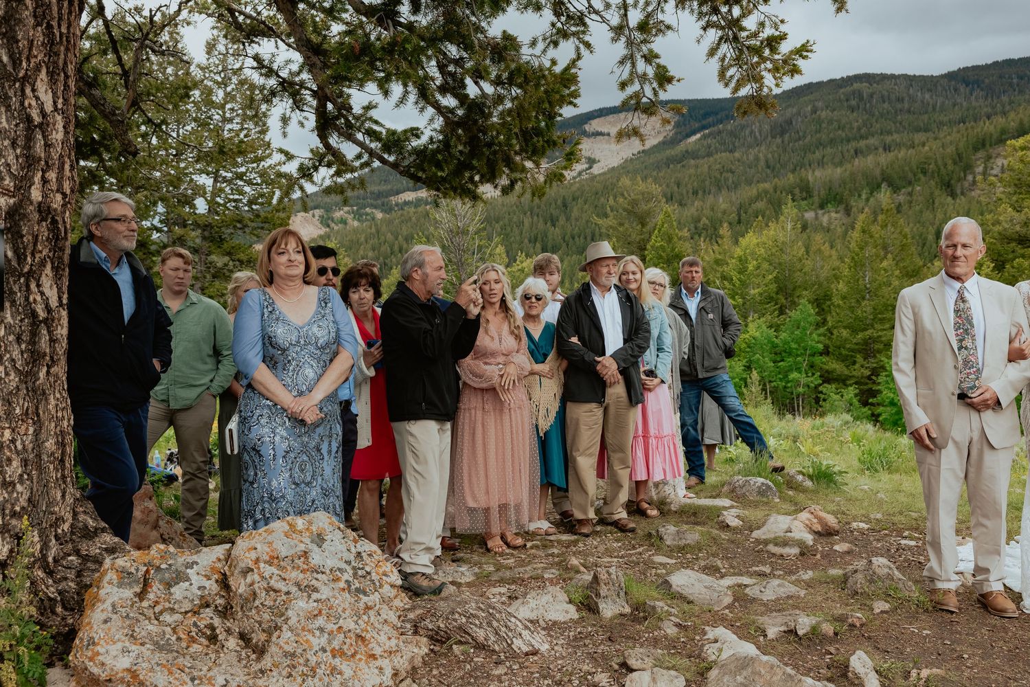 Wedding guests gathered on a scenic mountain overlook for an outdoor celebration.