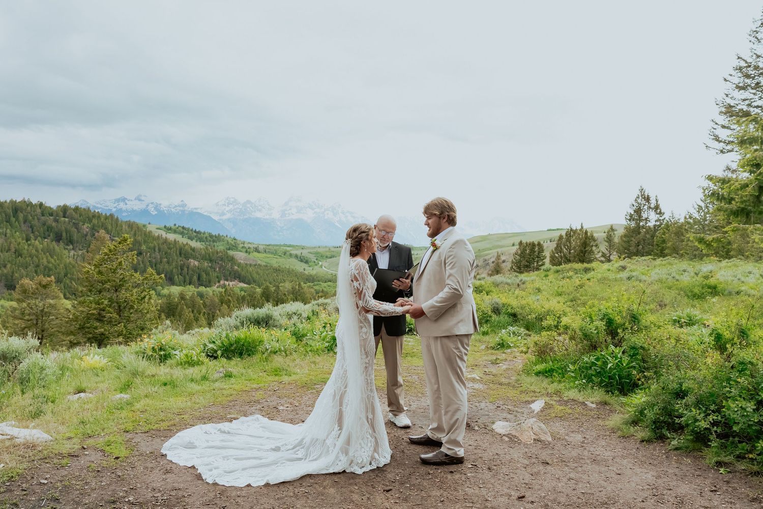 Romantic mountain wedding photography with dramatic landscapes and flowing white dress.