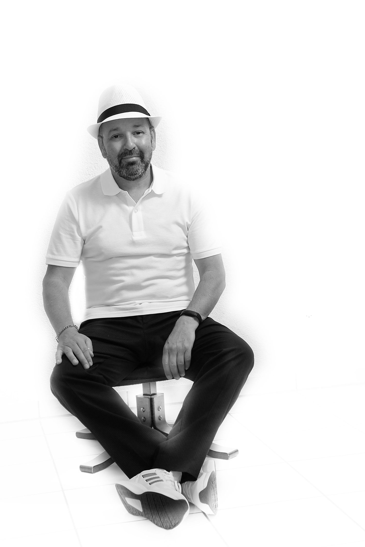 A sequence of four black and white photos showing someone sitting cross-legged on a white background.