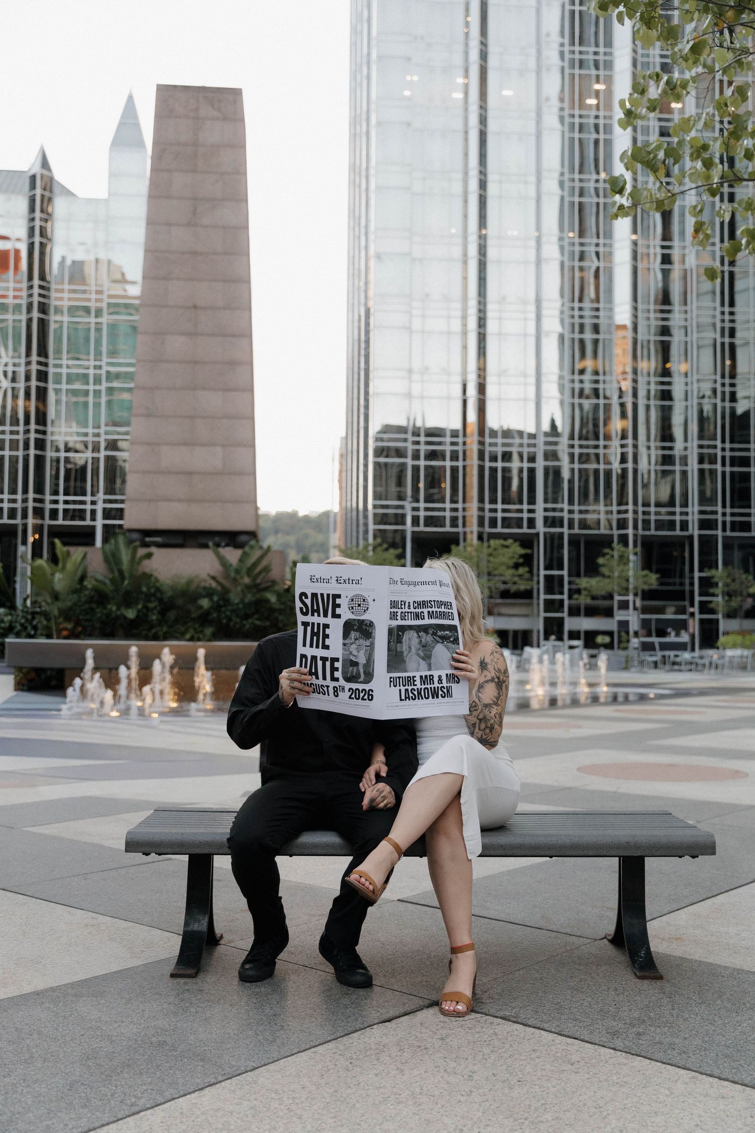 Performance art installation shows progressive movement across steel benches in front of a modern glass building.