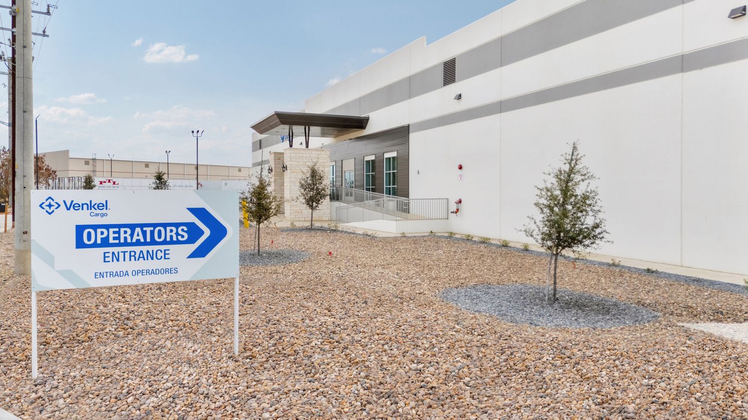 Panoramic view of a gravel-covered commercial rooftop with utility equipment and signage visible.