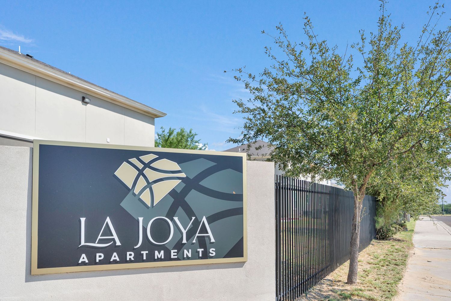 Exterior view of La Joya apartment complex entrance sign with modern architectural features and landscaping.