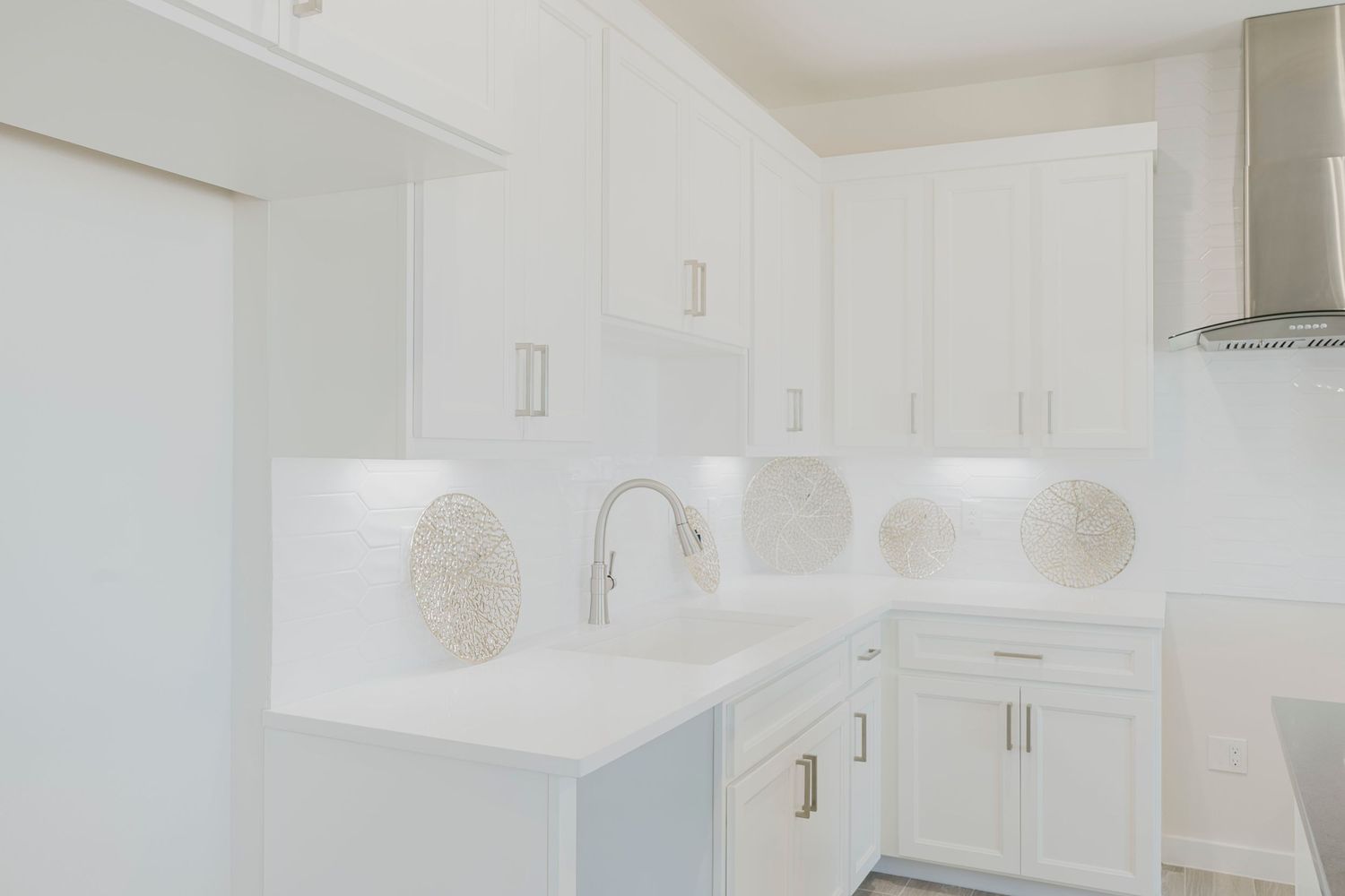 Clean white kitchen interior with minimalist design and quartz countertops.