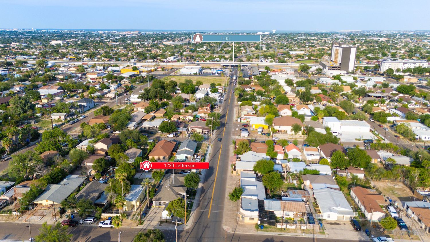 Aerial view of Hallandale Beach Florida neighborhood with residential houses and commercial buildings along main street.