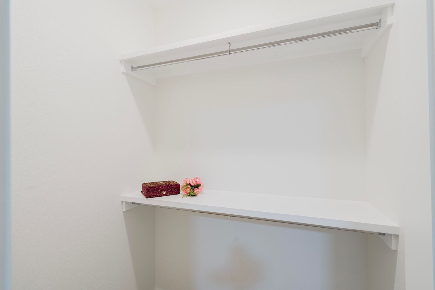 Simple white closet storage space with built-in shelving.