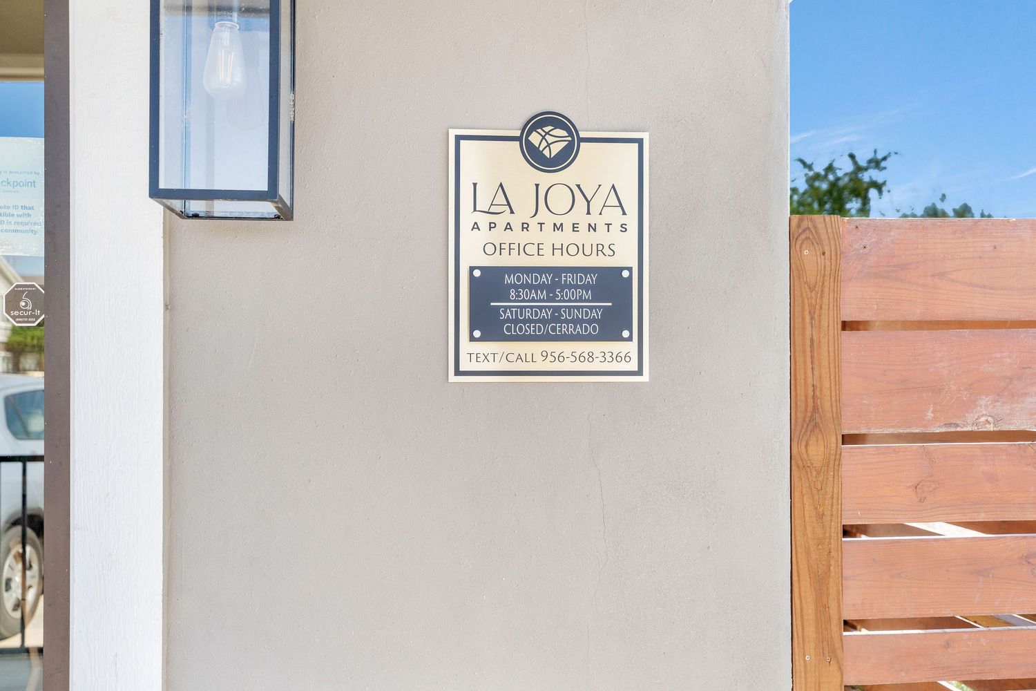 Exterior entrance of La Joya apartment complex with wooden fence and signage.