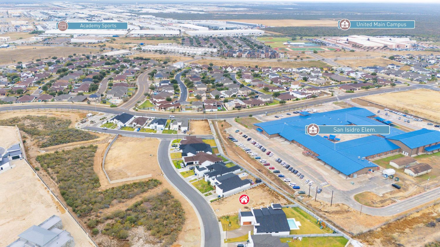 Aerial panoramic view of an industrial development area with warehouses and commercial buildings in a desert landscape.