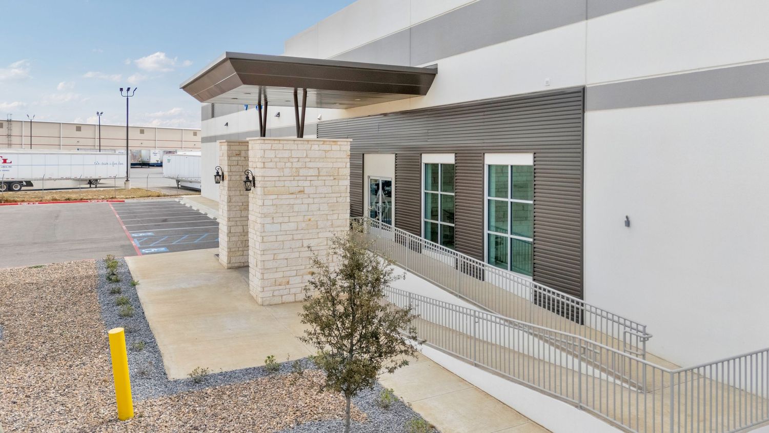 Modern commercial building exterior with concrete walls and metal railings shown from multiple angles in desert landscape.