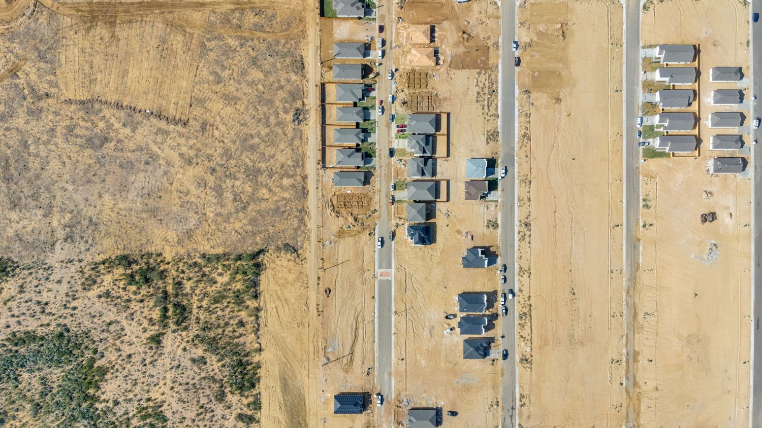 Aerial view of a desert industrial facility with rows of storage units and buildings arranged in a grid pattern.