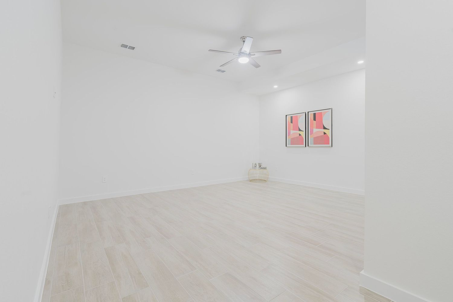 Open concept room with white walls, ceiling fan, and minimalist design.