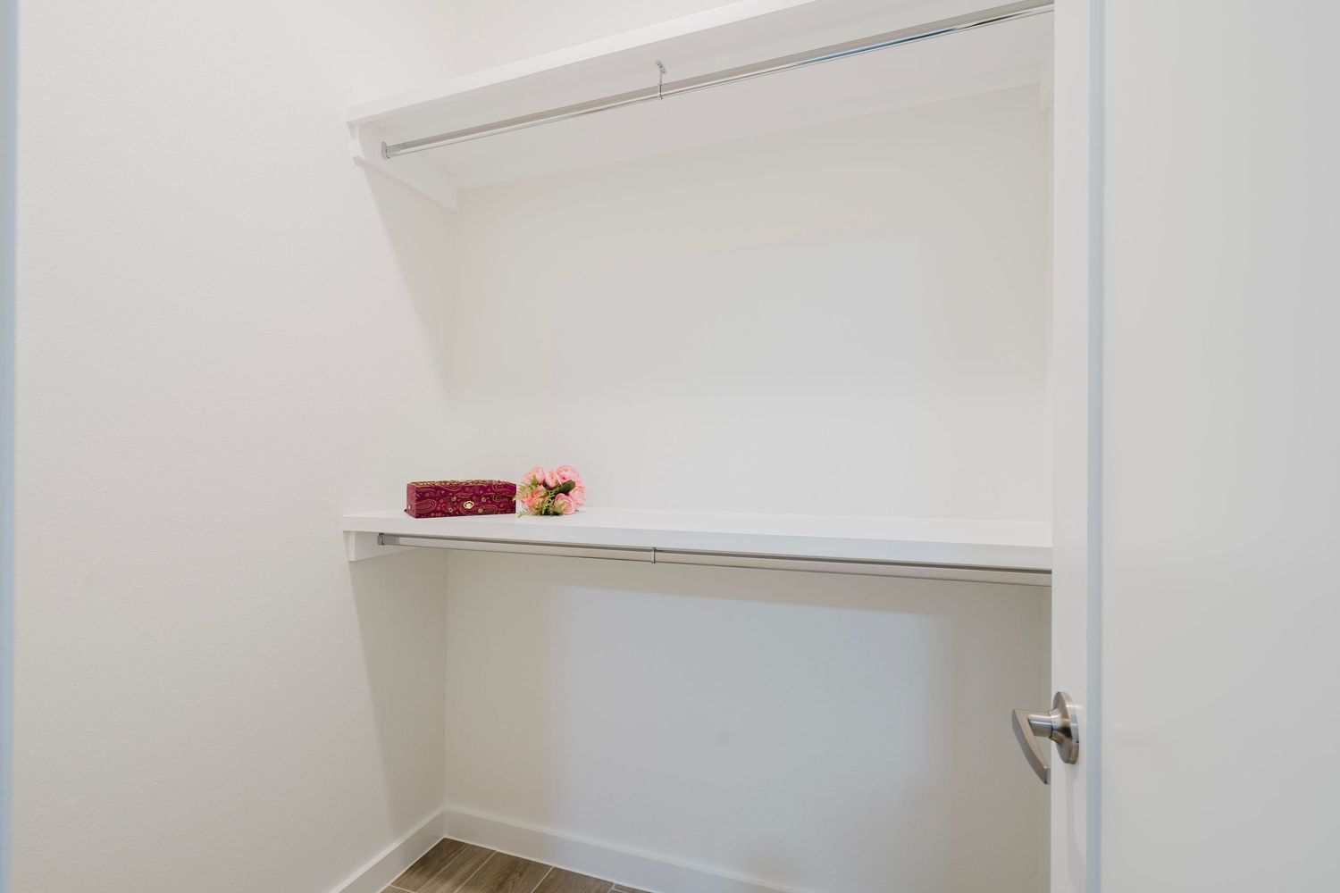 Built-in white closet shelf with small decorative items on display.