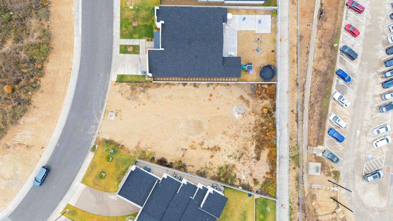 Aerial drone view of a modern suburban neighborhood with curved streets and residential homes.