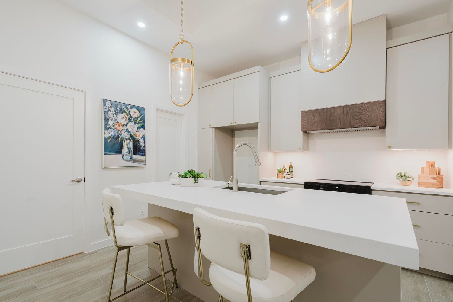 Modern white kitchen with floating breakfast bar, pendant lights, and contemporary bar stools.
