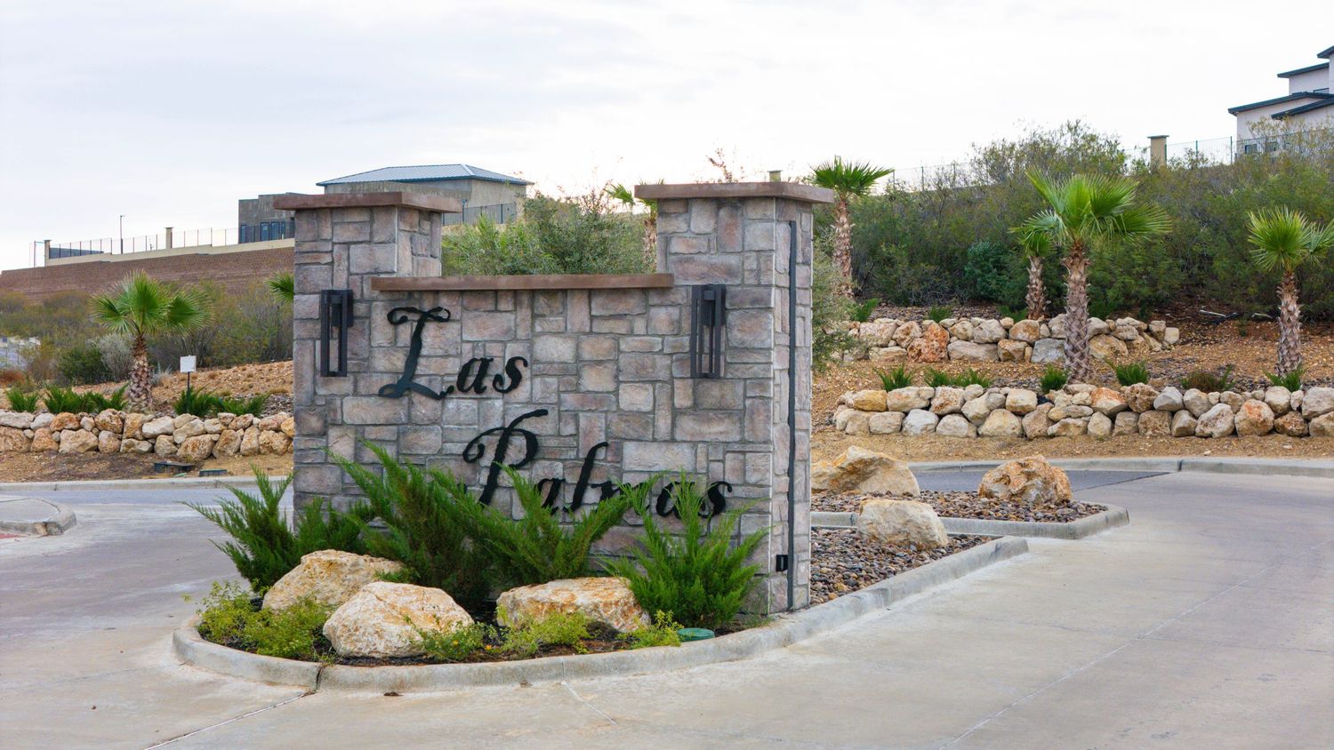 A panoramic view of a residential construction site with palm trees and partially built concrete structures.