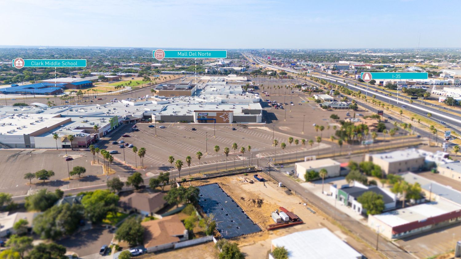 Aerial panorama of a port facility with container terminals, ships, and industrial buildings stretched along the waterfront.