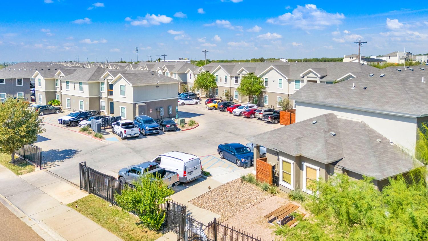 Aerial panoramic view of a residential neighborhood with houses and streets under blue skies.