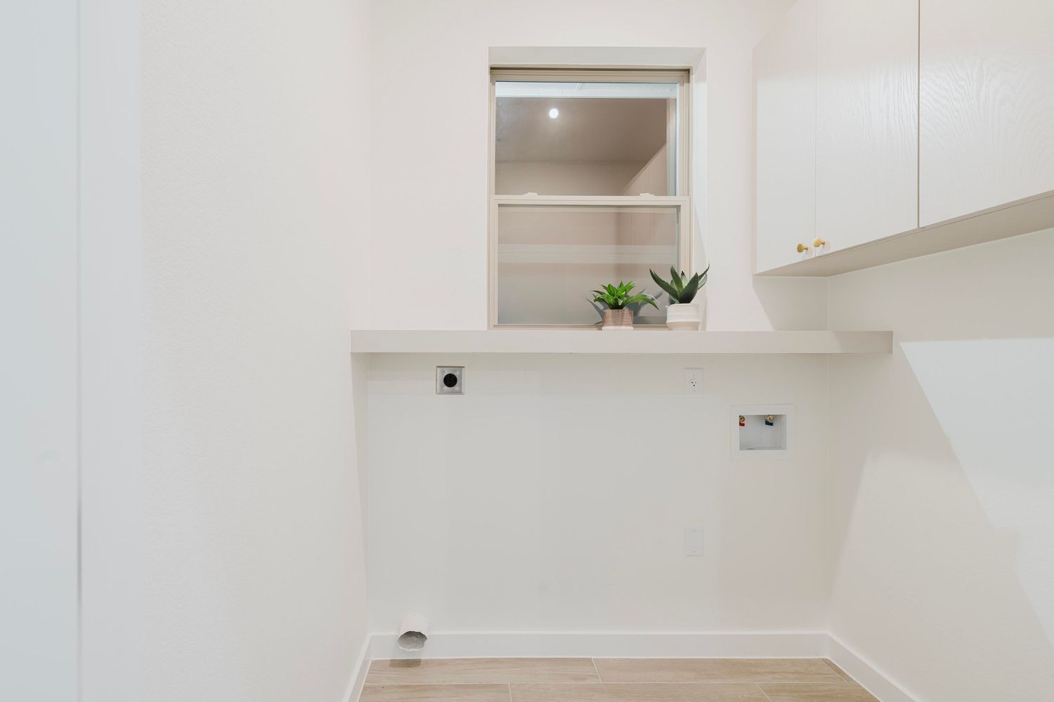 White built-in desk nook with floating shelf and recessed lighting.