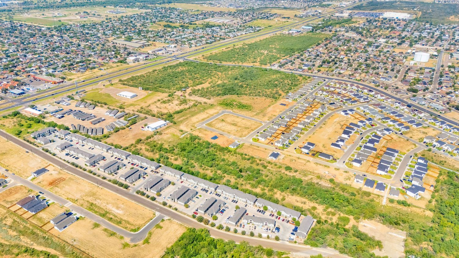 Bird's eye view of expanding residential neighborhoods with mixed housing developments.