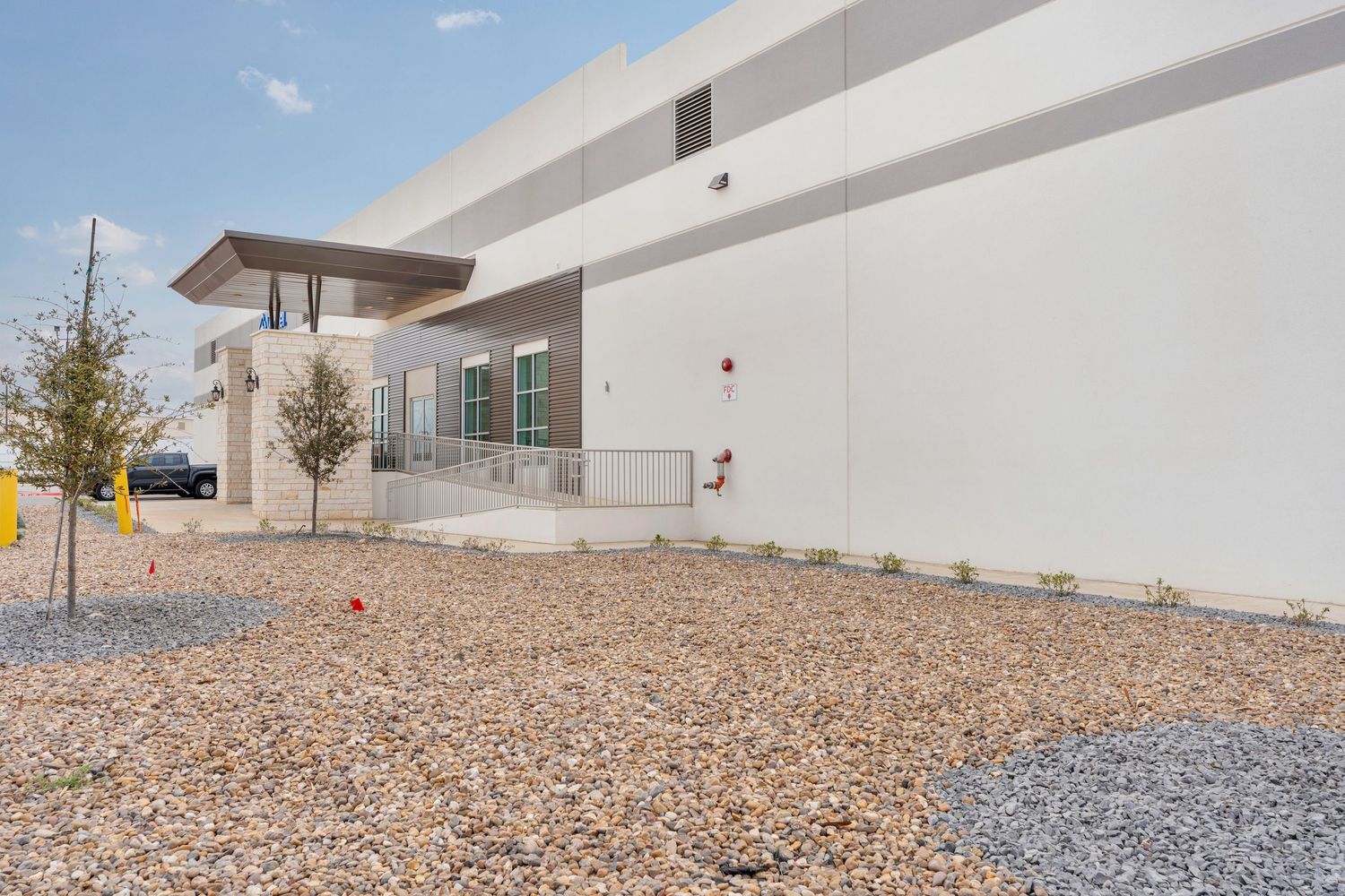 A series of exterior building shots showing modern architecture with gravel landscaping and clean lines.