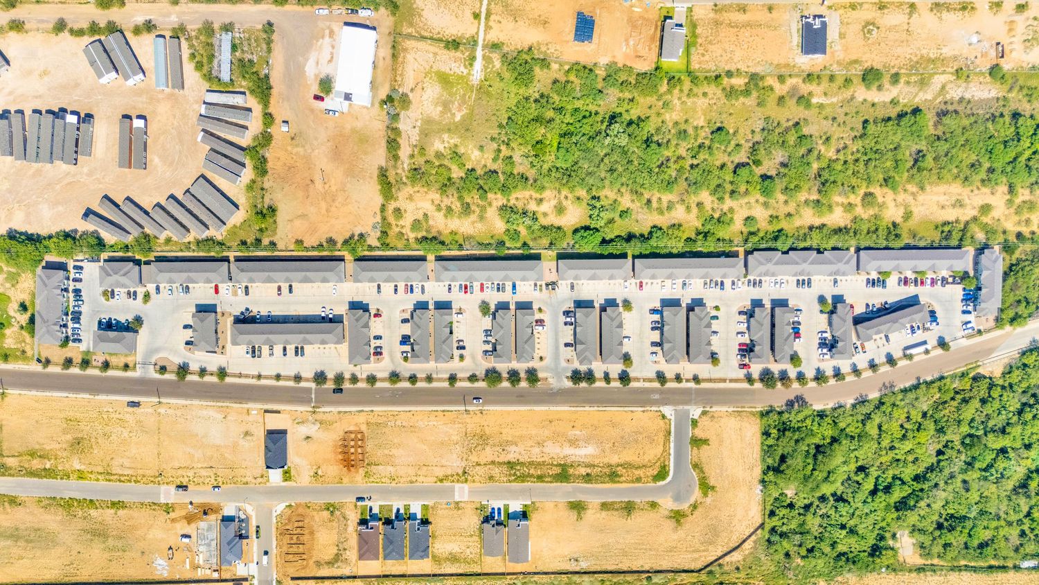 Overhead drone shot of a construction site with dirt roads and buildings in development.
