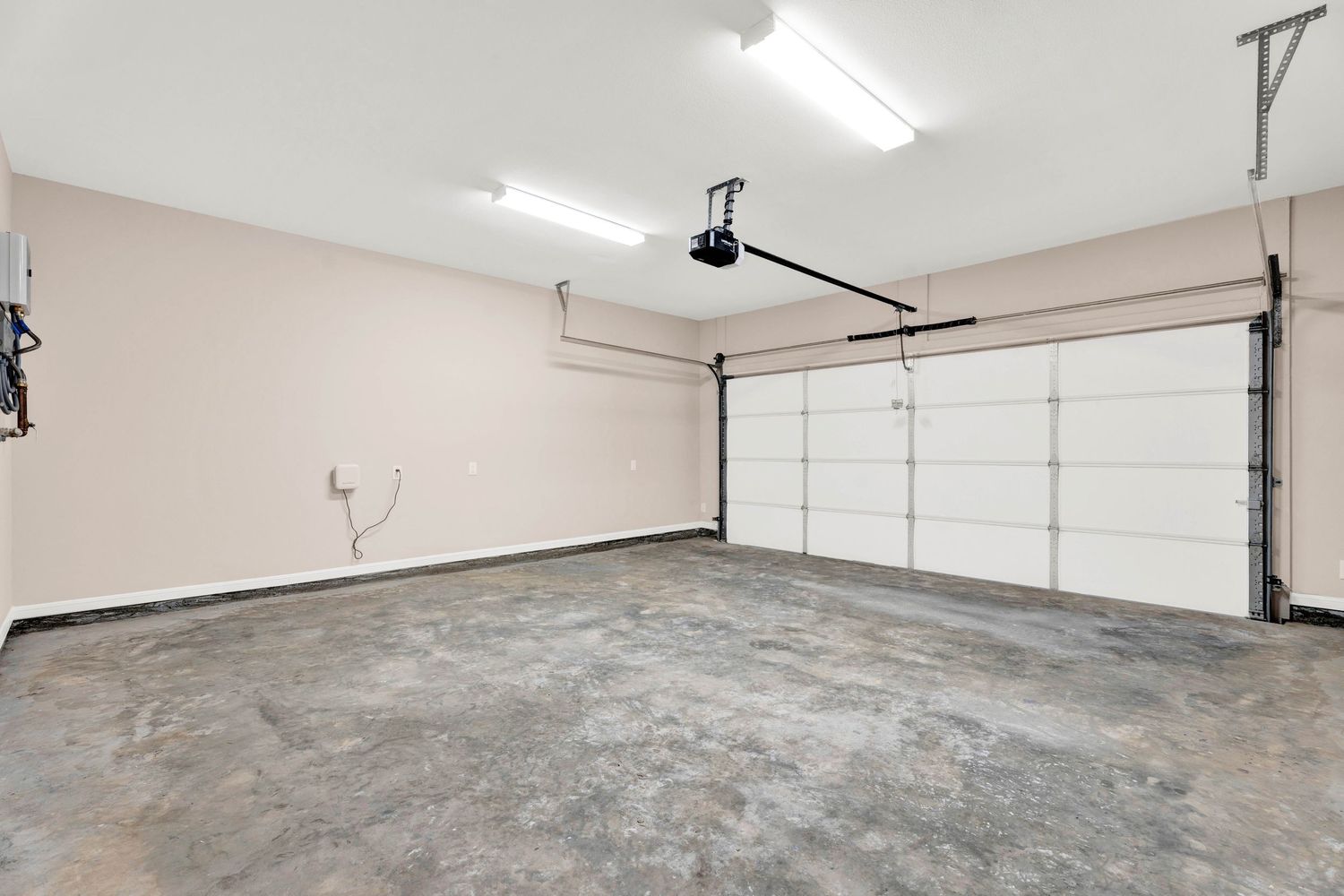 Spacious two-car garage with epoxy floors, automatic opener, and bright fluorescent lighting.