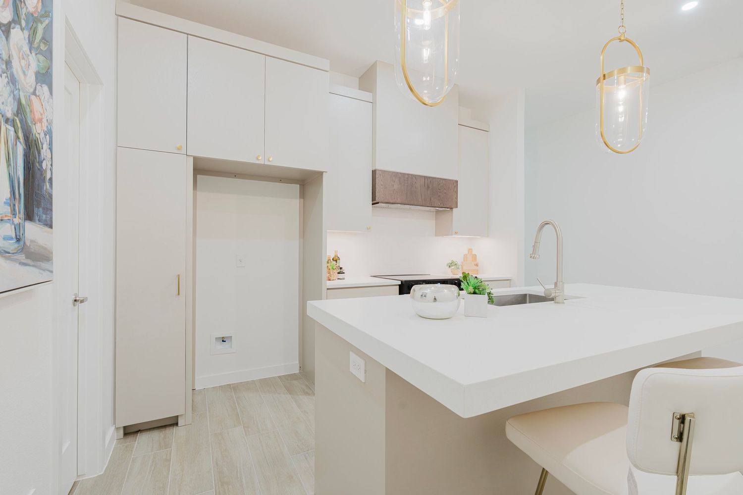 Sleek kitchen design with white countertops, pendant lighting, and light wood flooring.