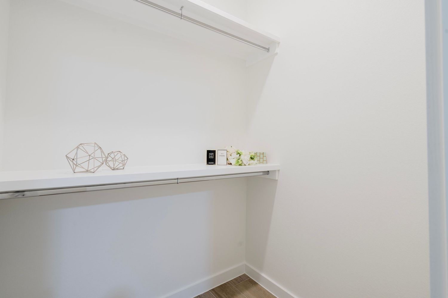 White closet space with built-in shelving and minimalist decor.