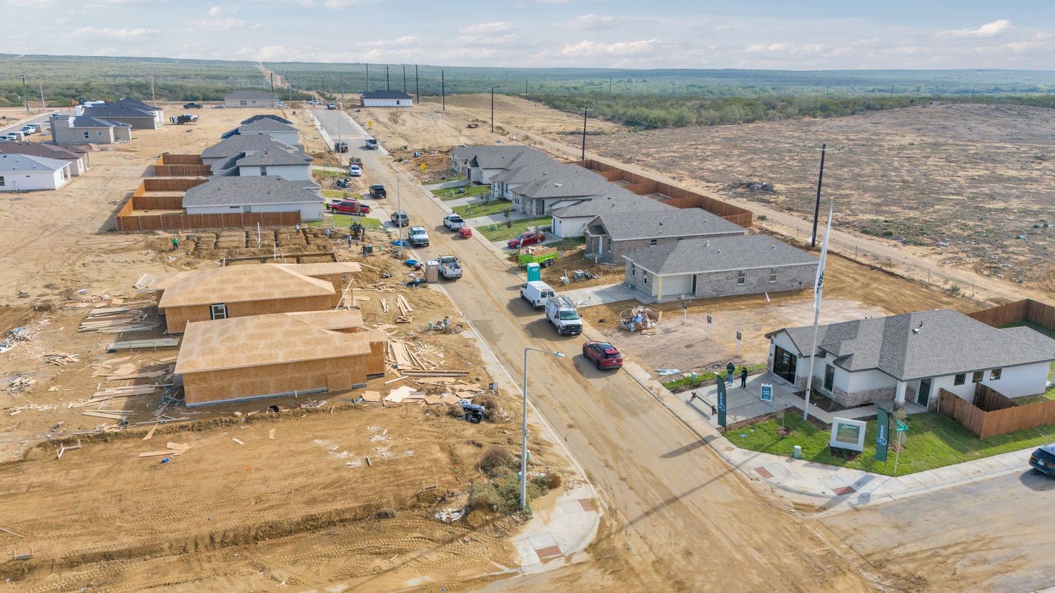 Aerial panoramic view of a large industrial construction site with earthworks and building foundations in progress.