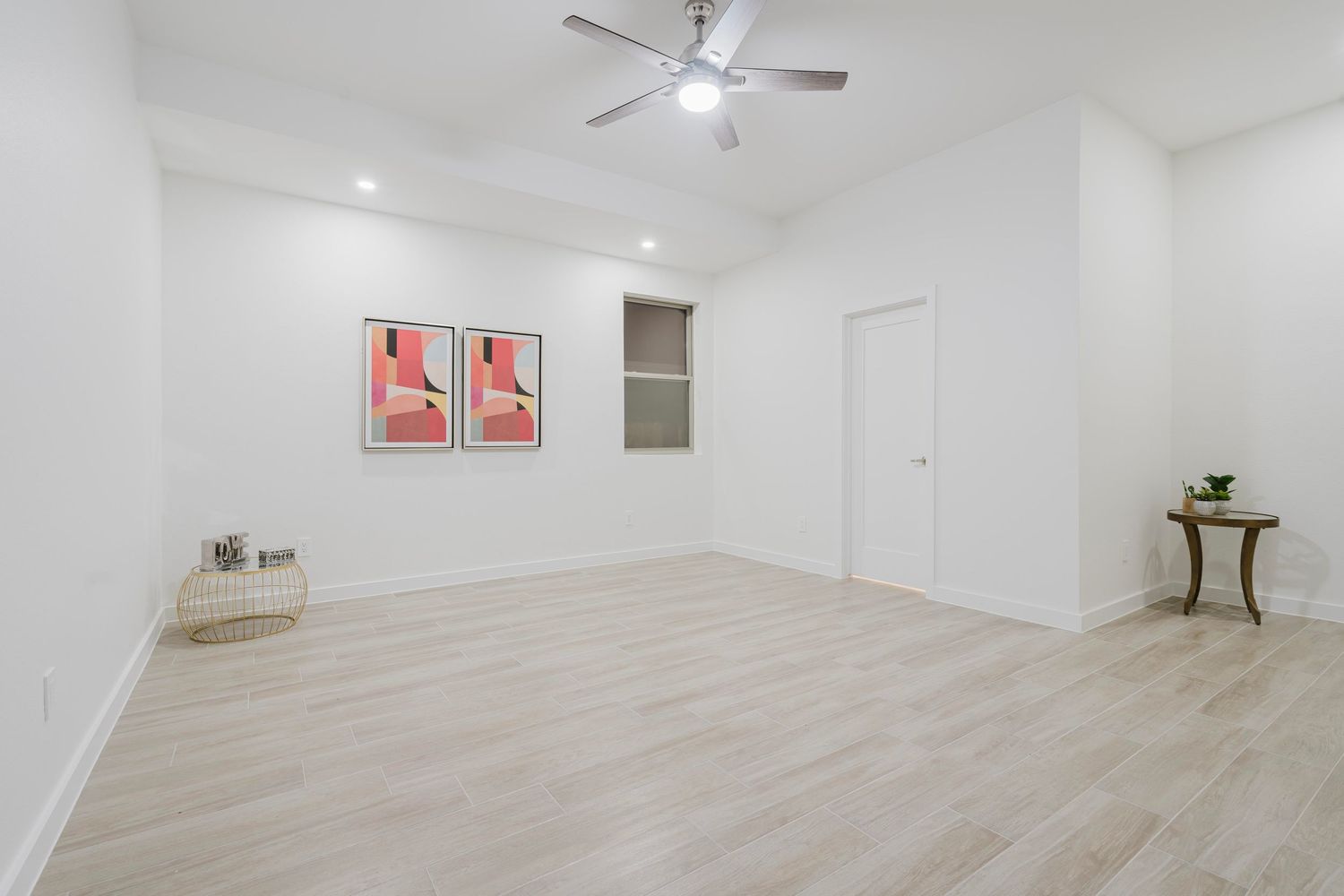 Modern room with light wood floors, red wall art, and antique side table.