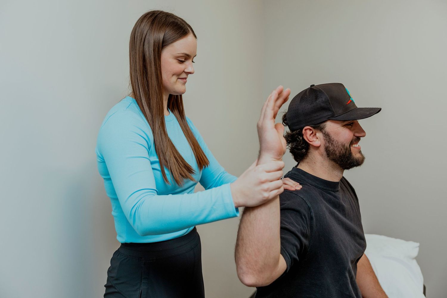 Physical therapist performs neck adjustment on patient during treatment session. Saskatchewan business branding content shoot. YXE, photos