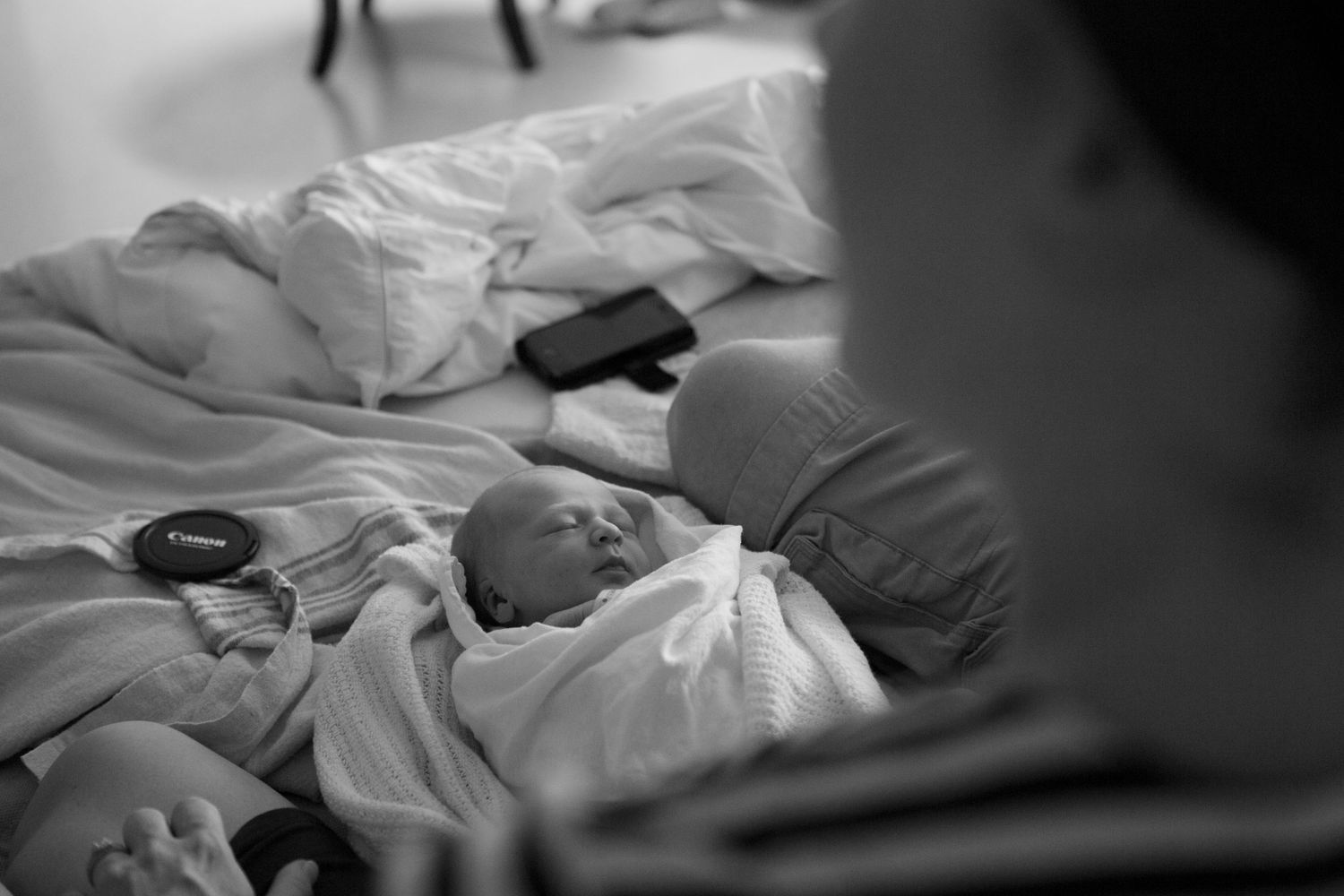 Black and white photo series showing a person lying in bed under white sheets in various sleeping positions.