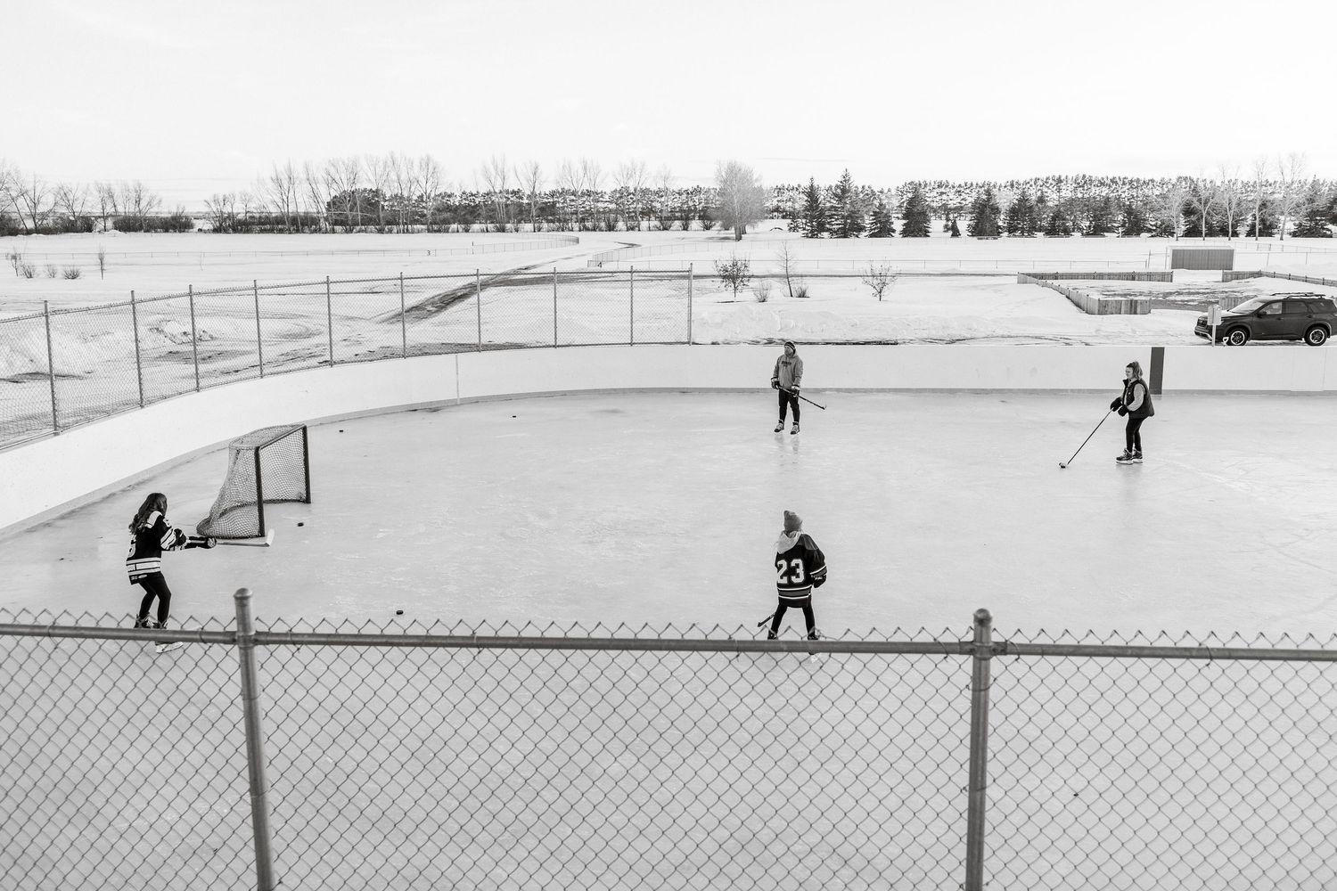 outdoor rink Saskatchewan childhood memories playing hockey as a family female hockey players candid hockey photos sask photographer