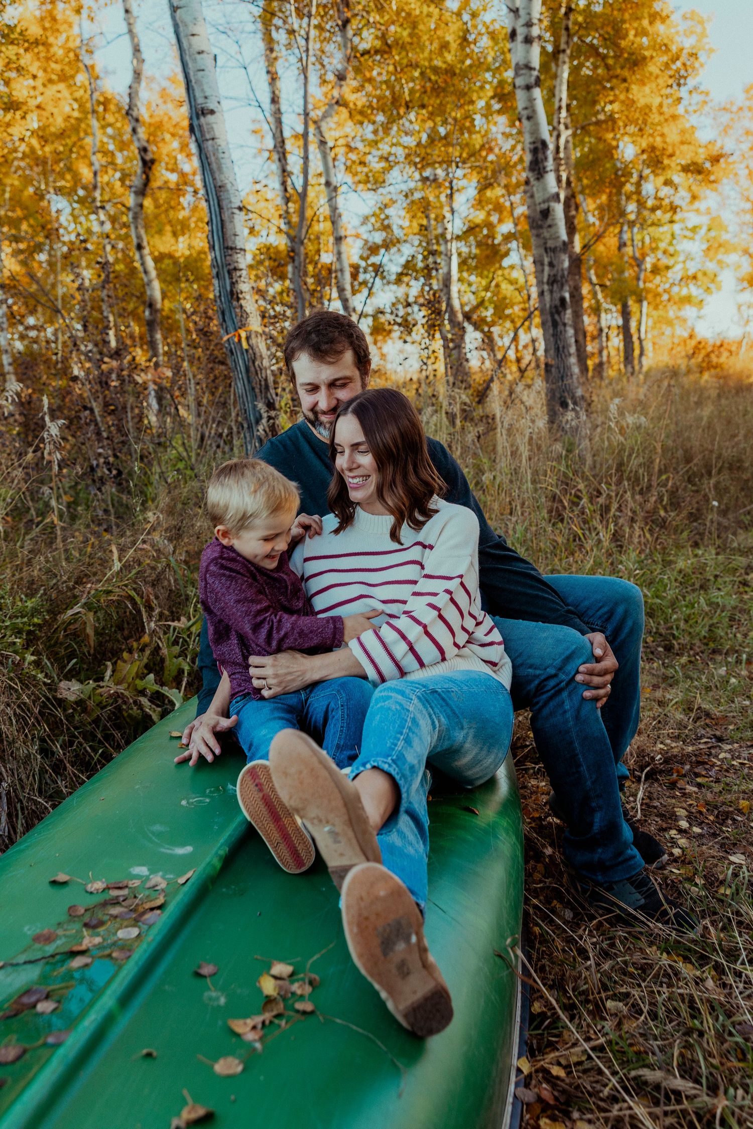 A sequence of playful moments captured on a green slide surrounded by autumn trees with golden foliage.