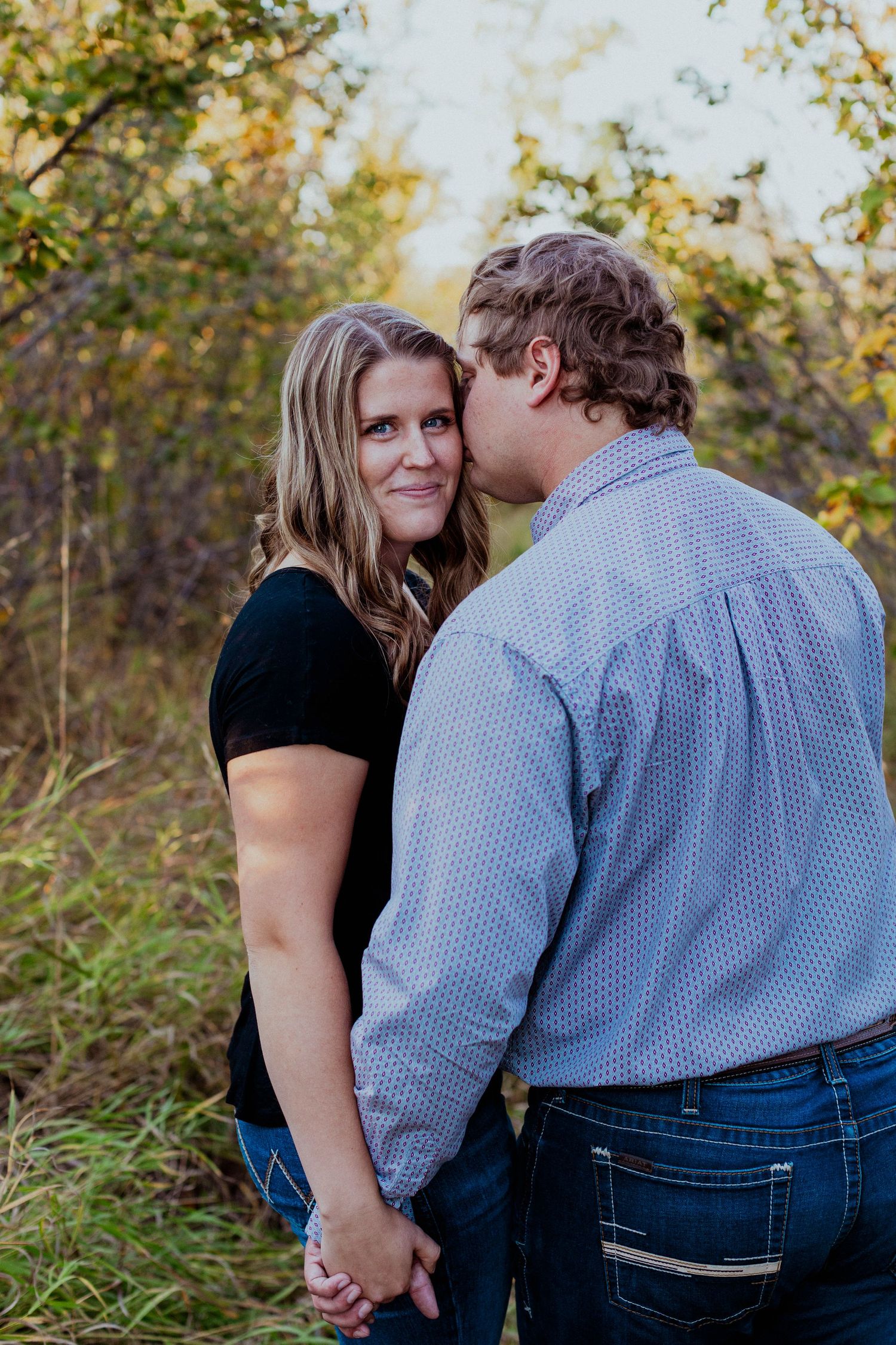 Couple sharing an intimate moment together outdoors during golden hour.