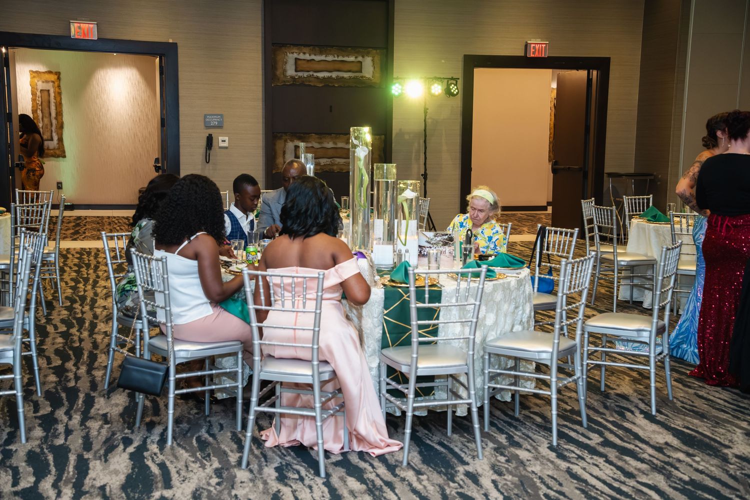 Elegant wedding reception setup with white Chiavari chairs and mint green accents in a banquet hall.
