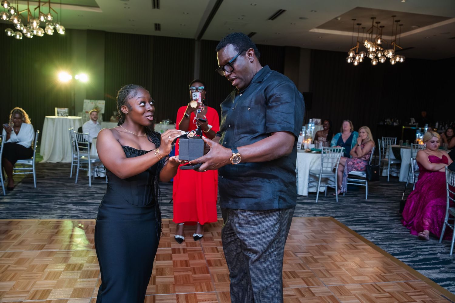 Couples dancing together on a wooden dance floor at an indoor social gathering event.