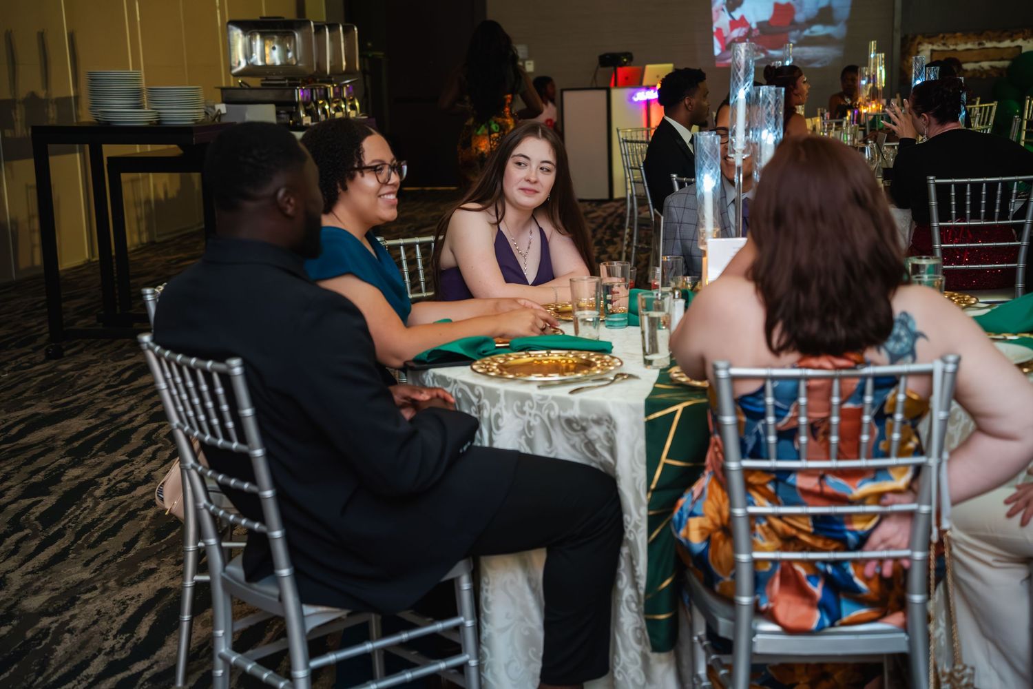 A group of people sit around a table playing board games at a social gathering.