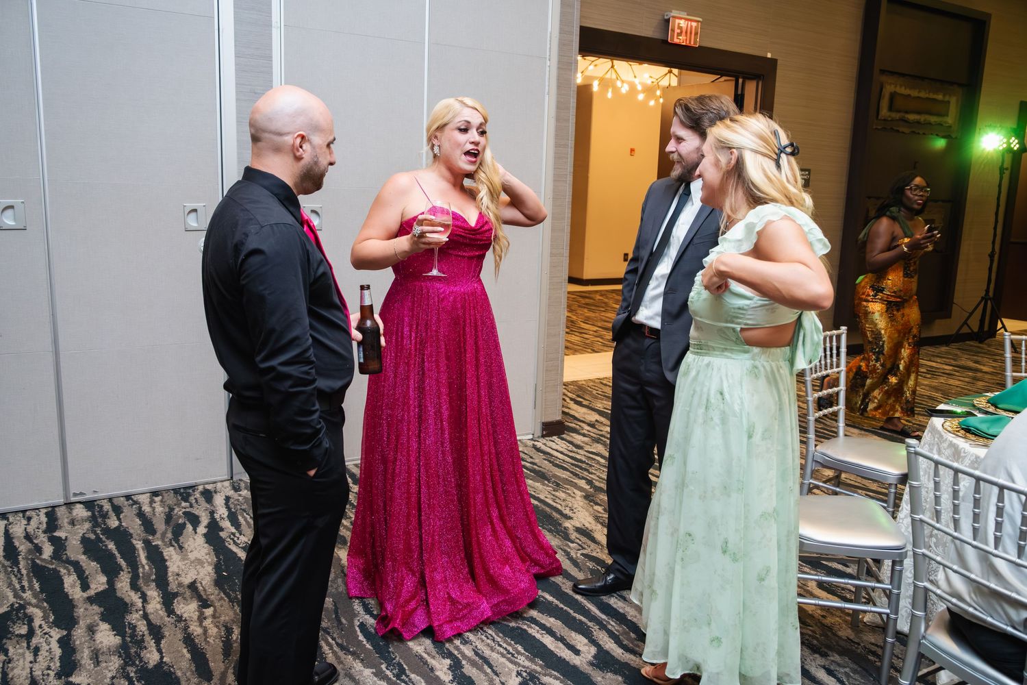 Dancers in formal attire move energetically on a dance floor at an elegant indoor event.