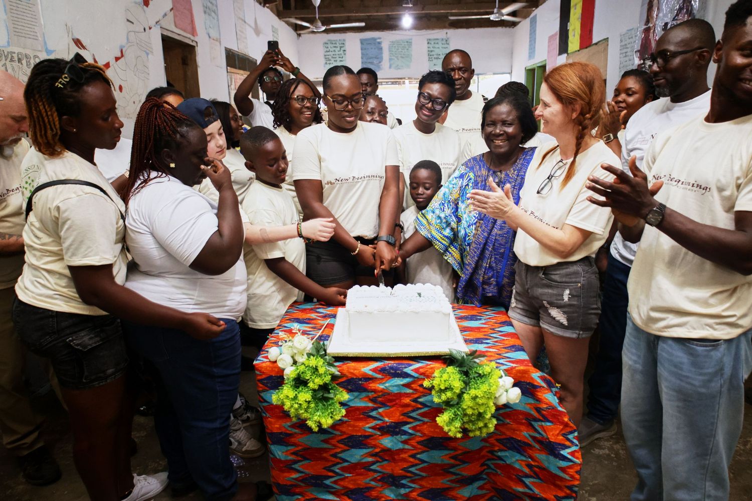 Group gathered around a decorated cake table during celebration event.