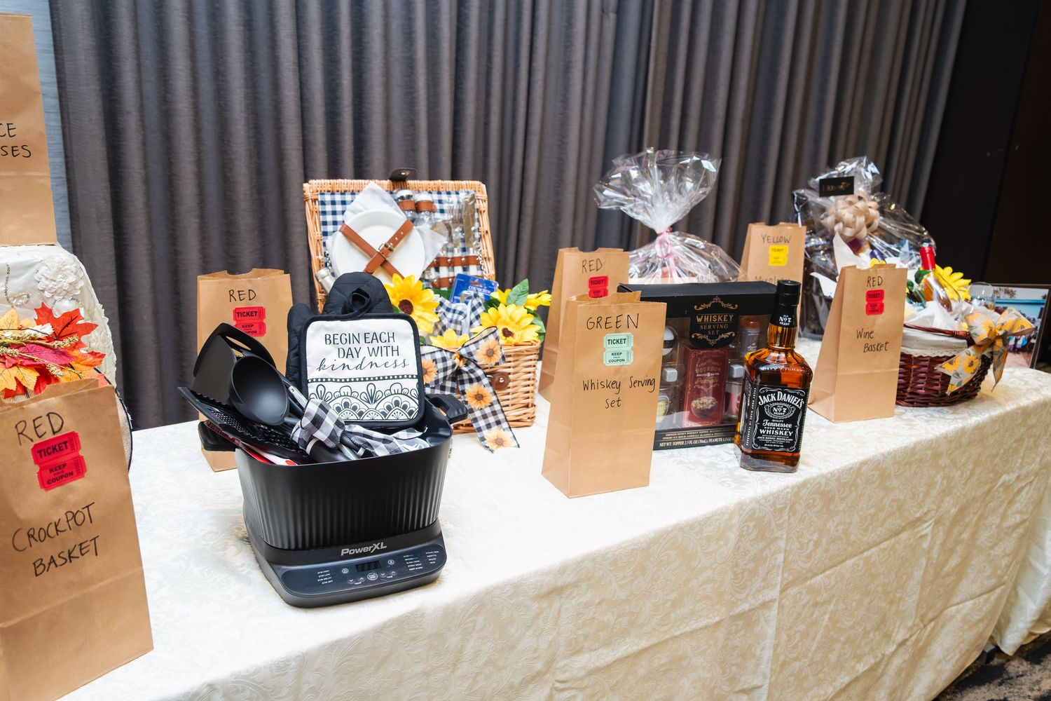 Long table display of packaged snacks and treats with brown paper bags lined up in a row.